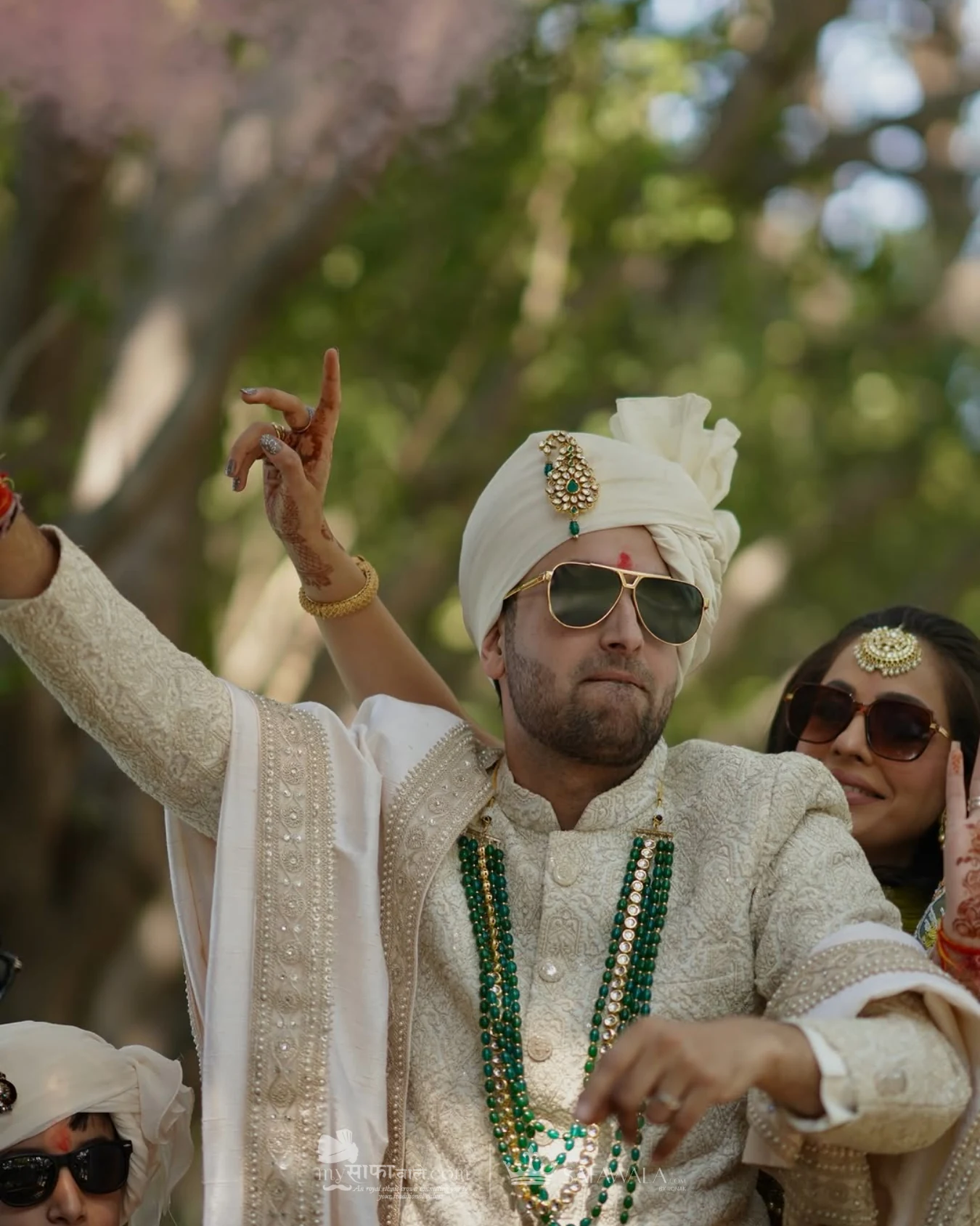 Groom in an ivory wedding safa with emerald jewellery for Family Pagdi Styling